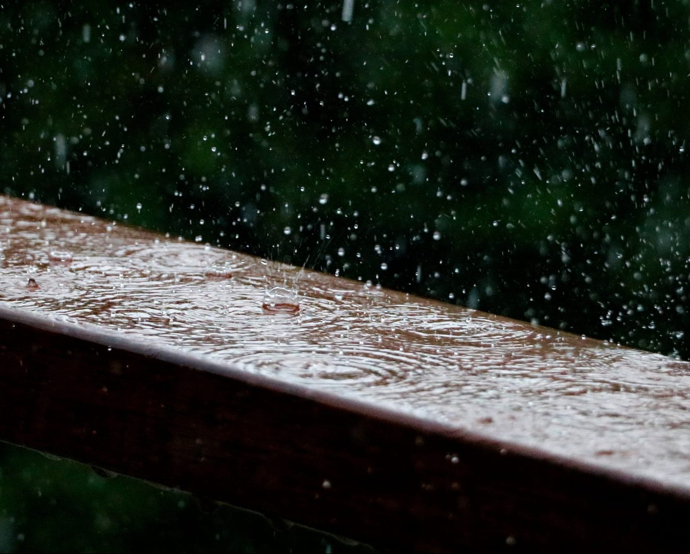 Rain drops fall upon a wooden surface